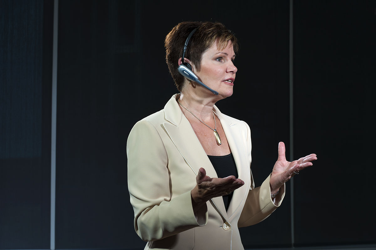 A professional woman talking while wearing a headset