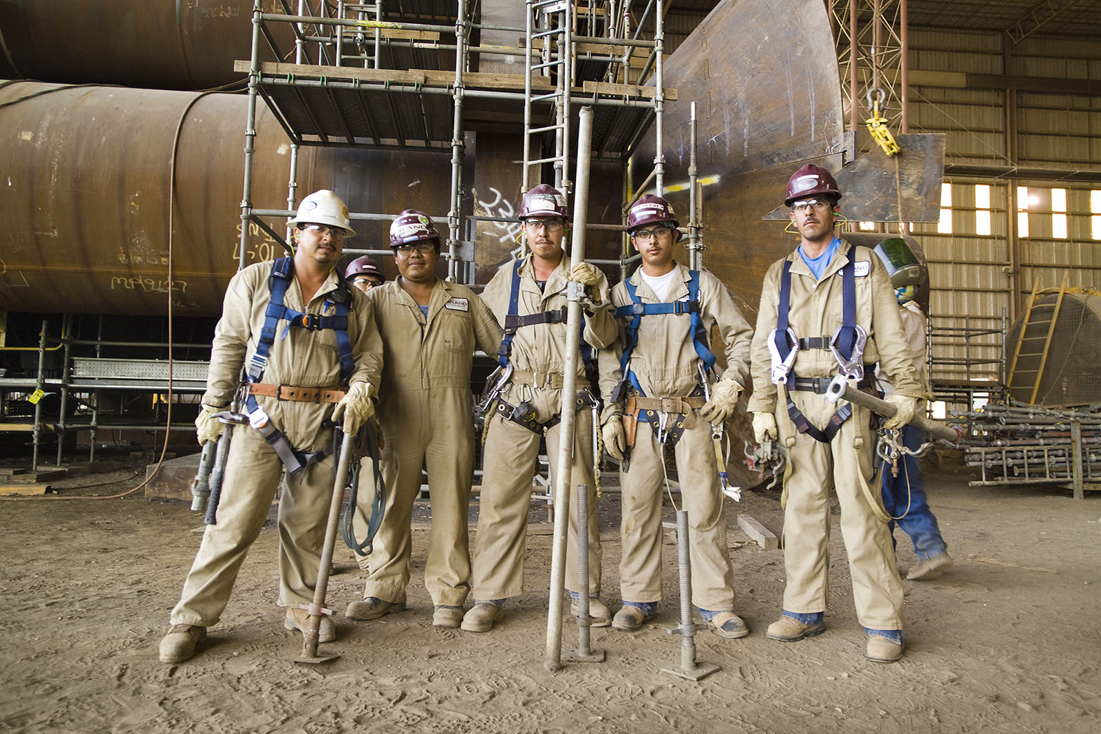 A team of five industrial workers in their protective gear